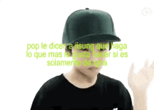 a man wearing a baseball cap and a black shirt is giving a peace sign .