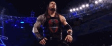 a wrestler with his arms in the air is standing on a stage .