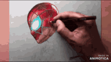 a person is drawing a spider-man head with a pencil