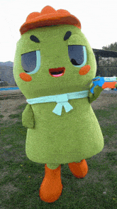 a green mascot with an orange hat and orange boots
