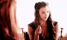 a woman in a plunging neckline is sitting next to another woman in a chair .
