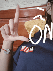 a person wearing a blue shirt with an american flag on it is making a peace sign