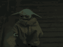 a baby yoda is walking down a set of stairs