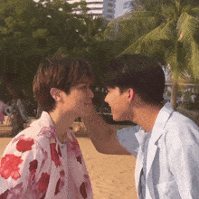 two men are touching each other 's foreheads on a beach