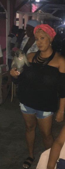 a woman is holding a small bird in her hands