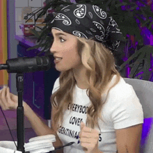 a woman wearing a bandana and a t-shirt that says everybody loves genocidia