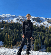 a man stands in front of a snowy mountain