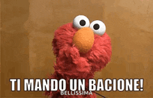 elmo from sesame street is holding a microphone and saying `` ti mando un bacione ! ''