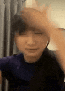 a close up of a person 's face with their eyes closed and their hand on their head .