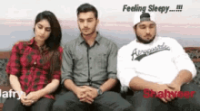 a group of people are sitting on a couch and one of them is wearing an aeropostale shirt .