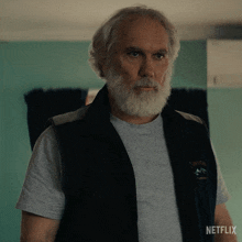 a man with a beard is wearing a vest that says netflix