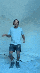 a man wearing headphones is jumping in the air while sitting on a wall .