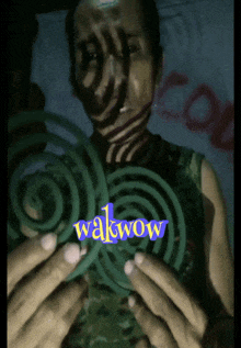 a man is holding a mosquito coil with the word wakwow written on it