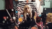 a woman in a costume is sitting on a couch surrounded by balloons and gifts