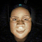 a close up of a person 's face with a mopar logo on her hat