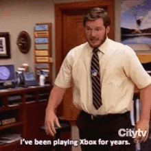 a man in a white shirt and tie is playing xbox