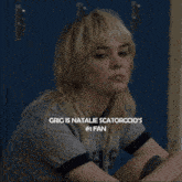 a woman with blonde hair is sitting in front of blue lockers and the caption says grig