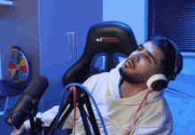 a man wearing headphones is sitting in front of a microphone with a chair that says gt ultimate on it