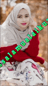 a woman wearing a hijab is sitting in front of a sign that says salamualiaiku