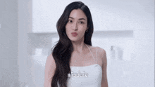 a woman in a white dress is smiling with a caption in another language