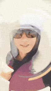 a woman wearing a helmet and sunglasses is smiling and looking at the camera .
