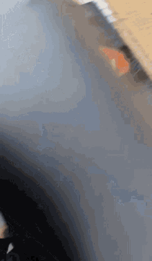a close up of a gray surface with a red triangle in the corner