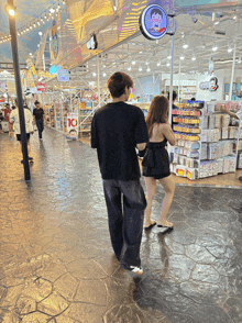 a man and a woman are walking in front of a store that has a sign that says 10