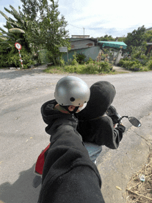 a person wearing a helmet is riding a motorcycle on a road