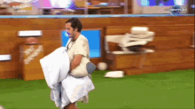 a man is holding a pillow in front of a tv screen that says ' big brother ' on it