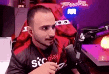 a man with a beard is sitting in front of a microphone in a chair .