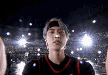 a young man wearing a headband stands in front of a crowd