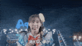 a girl with a flower in her hair is singing in front of a sign that says a9