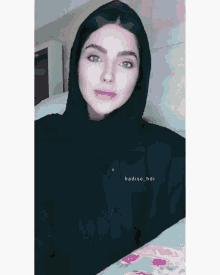 a woman wearing a black shirt with the name hadise_hdi on the front