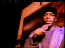 a man in a hat is holding a microphone in his right hand