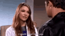 a woman in a lab coat is talking to a man in a leather jacket in a hospital room .