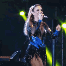 a woman singing into a microphone on stage