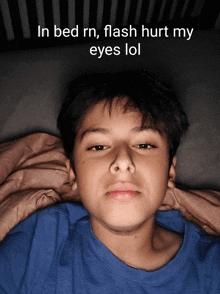 a young boy is laying in bed with a caption that says in bed rn flash hurt my eyes lol