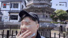 a man wearing a face mask stands in front of a tower and a recorder that says rec