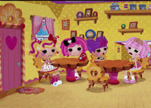 a group of dolls are sitting around a table with a gingerbread man on it
