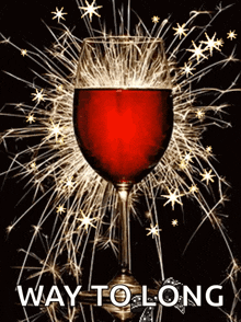 a glass of red wine is surrounded by sparklers and the words way to long are below it
