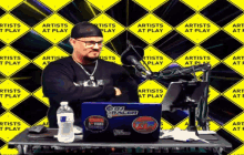 a man sitting at a table with a laptop that says dj racer