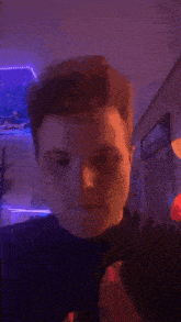 a man is dancing in a room with purple lights