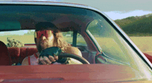 a man wearing sunglasses and gloves is driving a car
