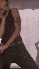 a man in a black tank top is holding a microphone in his hand