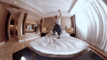 a man jumping on a bed in a hotel room