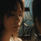 a close up of a woman 's face with a fence in the background