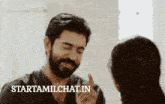 a man with a beard is talking to a woman and the website starttamilchat.in is behind him