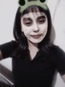 a girl wearing a headband with frog ears on it