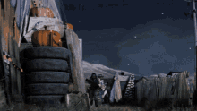 a man with a gun running in front of a stack of tires and a pumpkin that says halloween