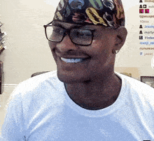 a man wearing glasses and a bandana is smiling